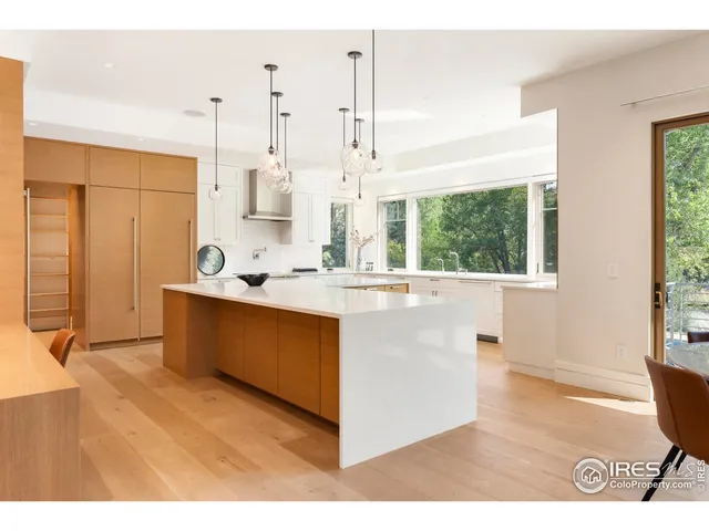 a kitchen with stainless steel appliances kitchen island granite countertop a sink cabinets and wooden floor