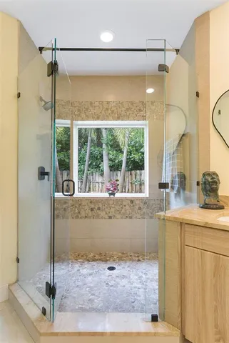 a bathroom with a granite countertop sink mirror and shower