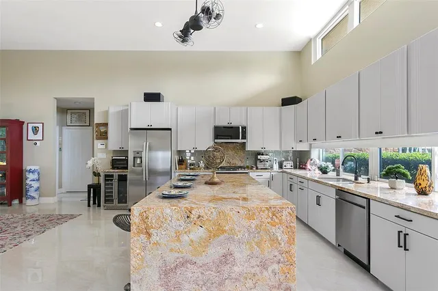 a kitchen with sink a counter top space appliances and cabinets