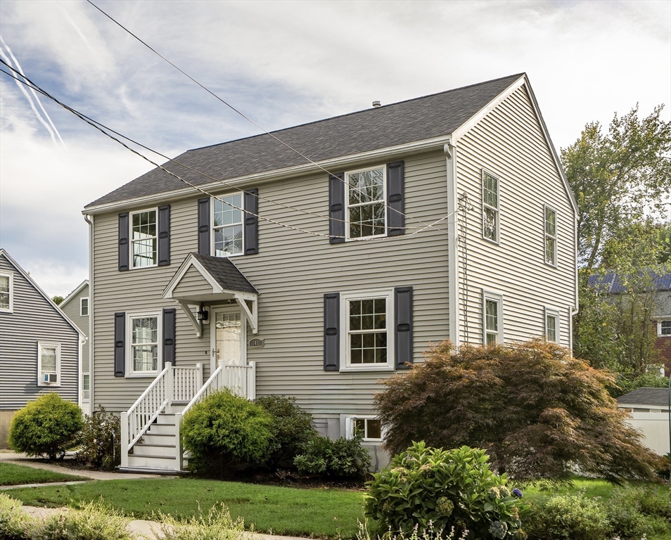 a front view of a house with a yard and trees
