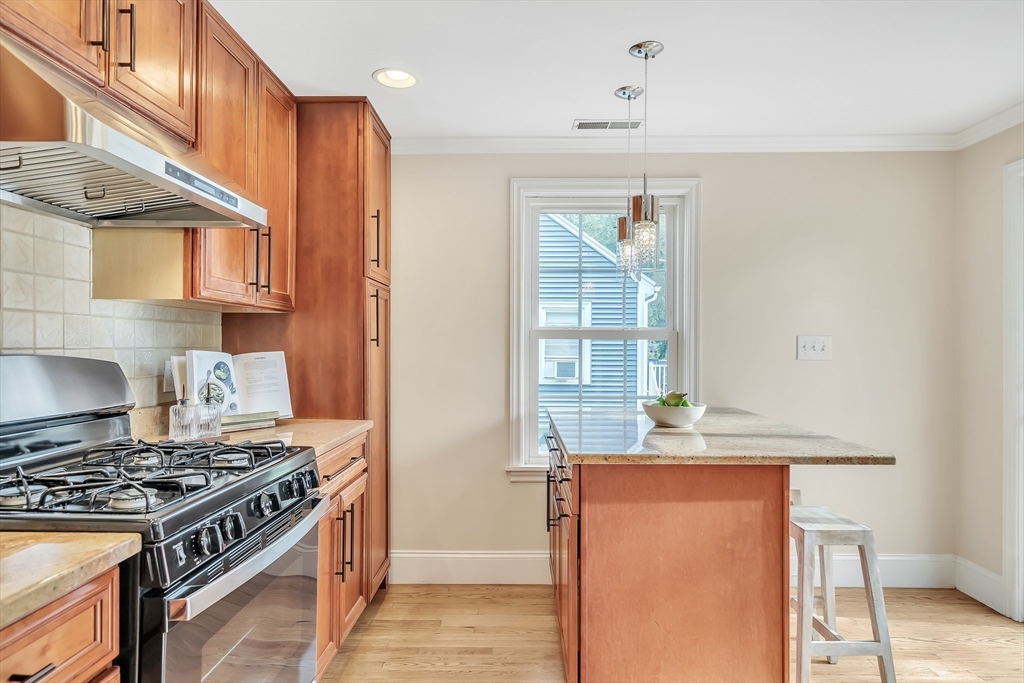 141 Renfrew Street Arlington, MA 02476 - Photo 14 of 41 a kitchen with stainless steel appliances granite countertop a stove and a refrigerator