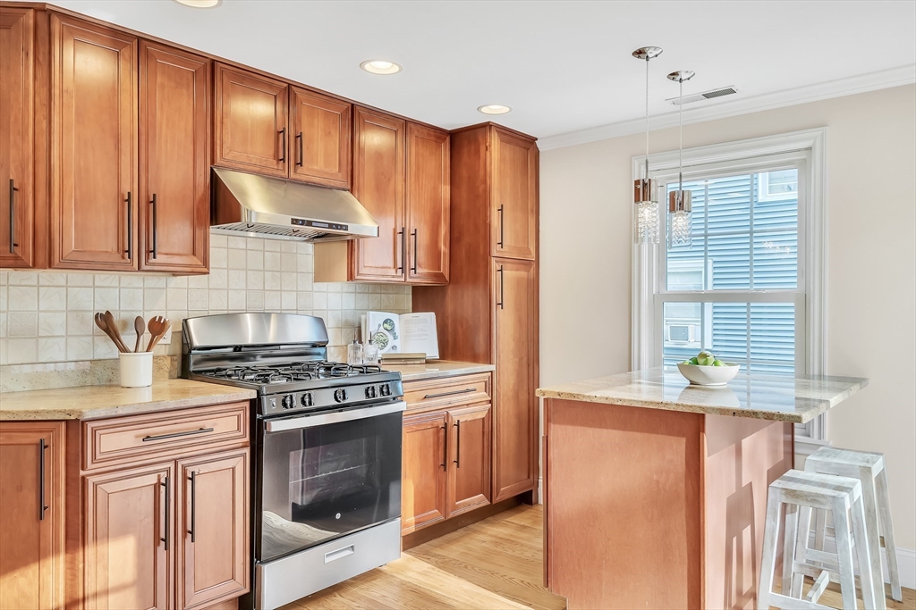 141 Renfrew Street Arlington, MA 02476 - Photo 17 of 41 a kitchen with stainless steel appliances granite countertop a stove a sink and a microwave