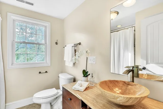 a bathroom with a granite countertop sink toilet and a mirror