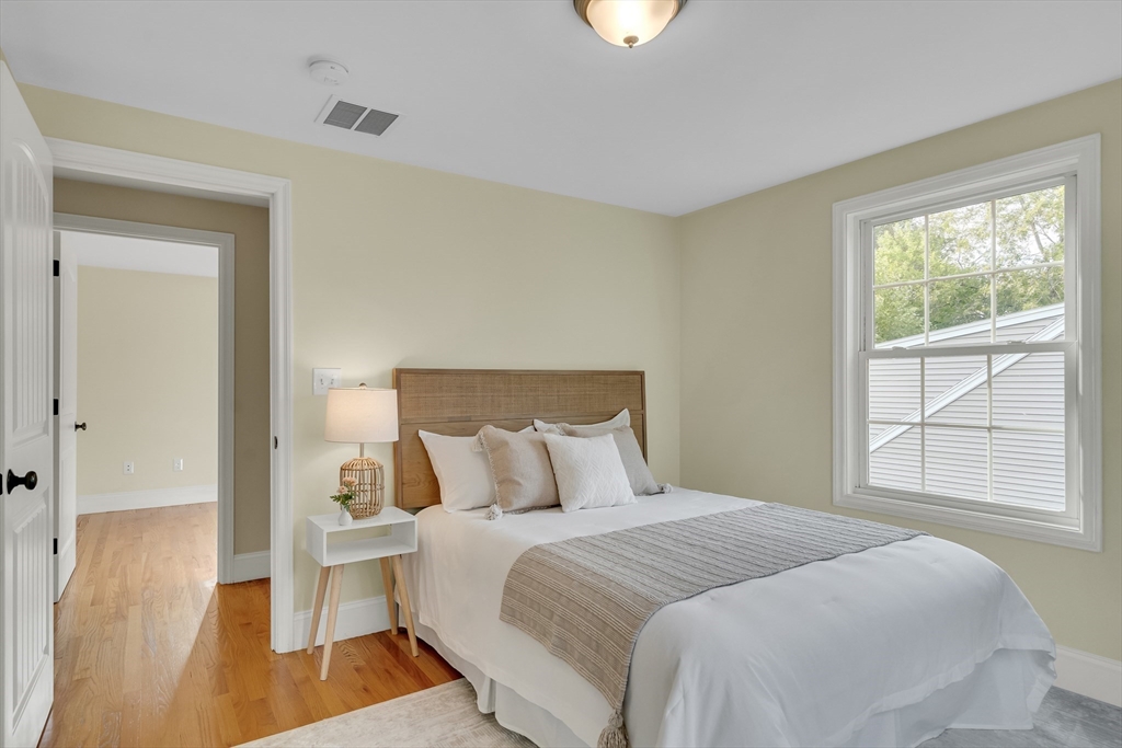 141 Renfrew Street Arlington, MA 02476 - Photo 29 of 41 a bedroom with a bed and wooden floor
