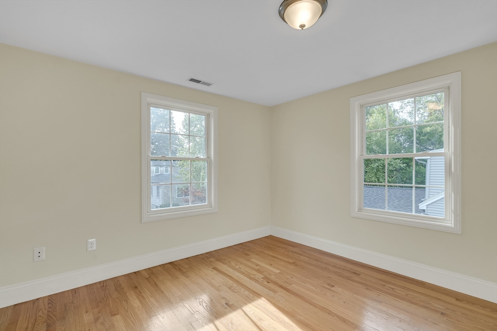 141 Renfrew Street Arlington, MA 02476 - Photo 31 of 41 a view of an empty room with wooden floor and a window