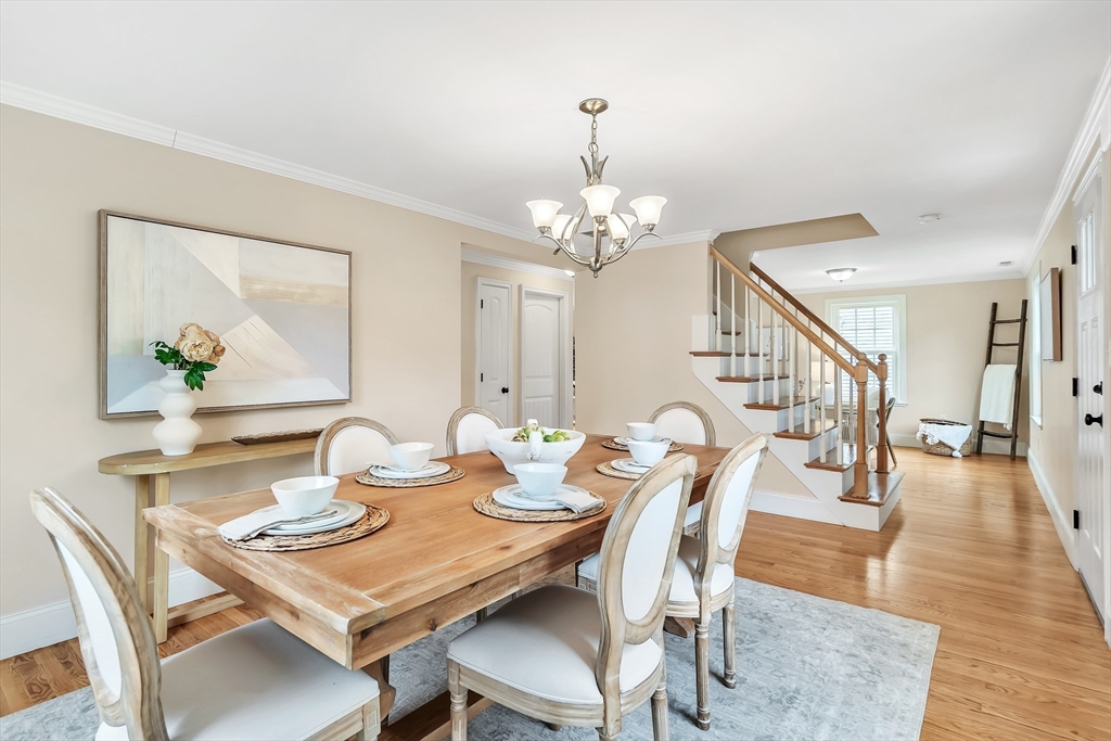 141 Renfrew Street Arlington, MA 02476 - Photo 5 of 41 a dining room with wooden floor a chandelier a wooden table and chairs