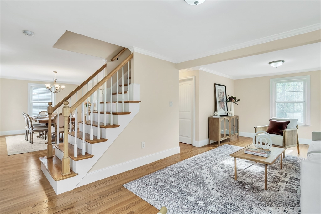 141 Renfrew Street Arlington, MA 02476 - Photo 7 of 41 a living room with furniture and a dining table with wooden floor