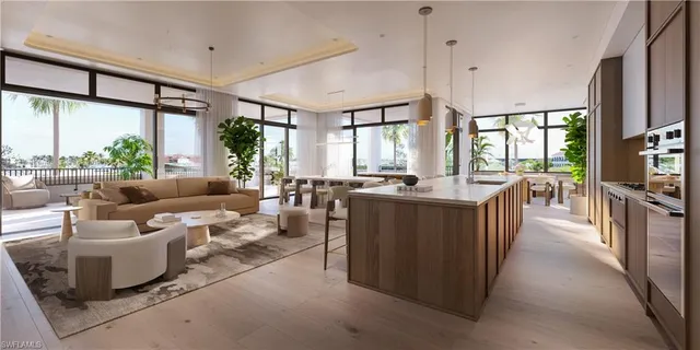 a living room with couches a flat screen tv next to a large window with kitchen view