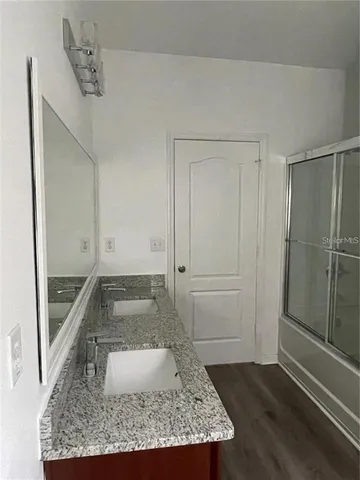 a bathroom with a granite countertop sink and a mirror