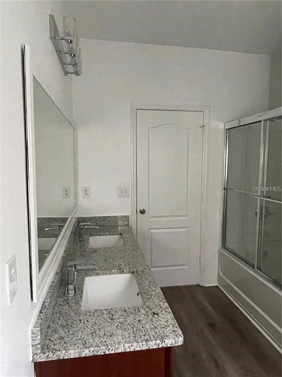 3731 Seneca Club Loop, Unit B Orlando, FL 32808 - Photo 15 of 32 a bathroom with a granite countertop sink and a mirror