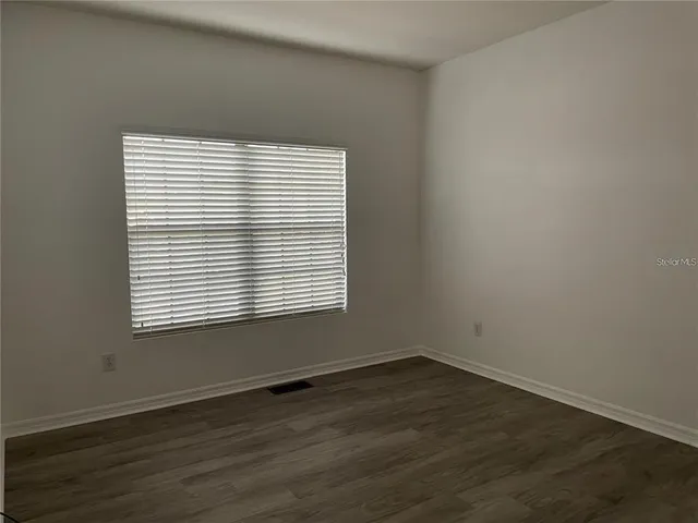 an empty room with wooden floor and a window