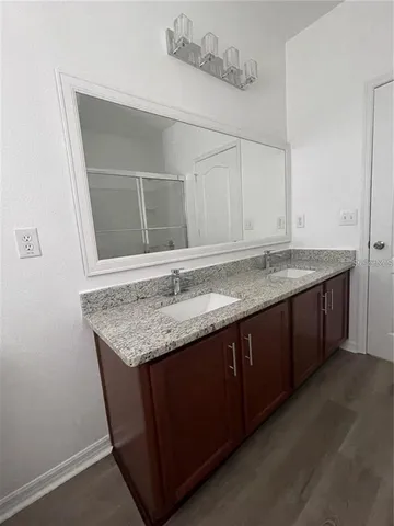 a bathroom with a granite countertop sink and a mirror