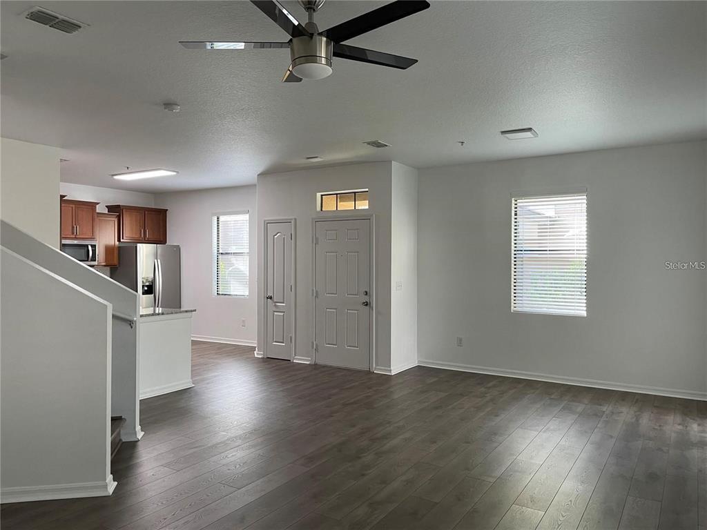 3731 Seneca Club Loop, Unit B Orlando, FL 32808 - Photo 4 of 32 an empty room with wooden floor cabinet and windows