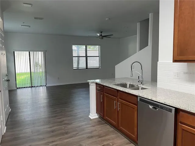 a kitchen with sink a window and wooden floor