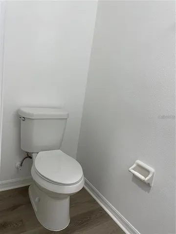 a white toilet sitting next to a white wall