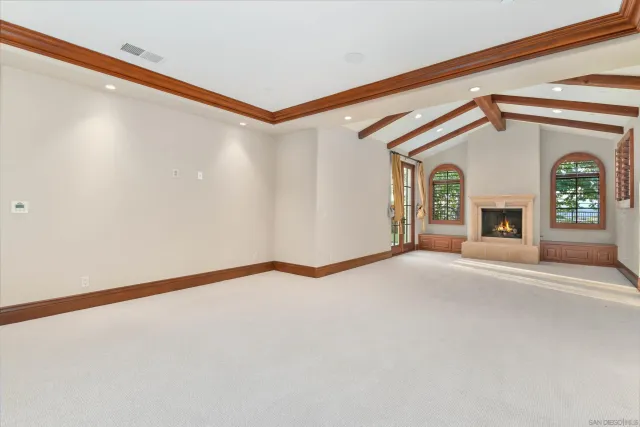 a view of an empty room with a fireplace and a window