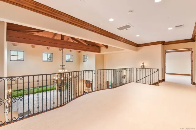 a view of an empty room with wooden floor and windows