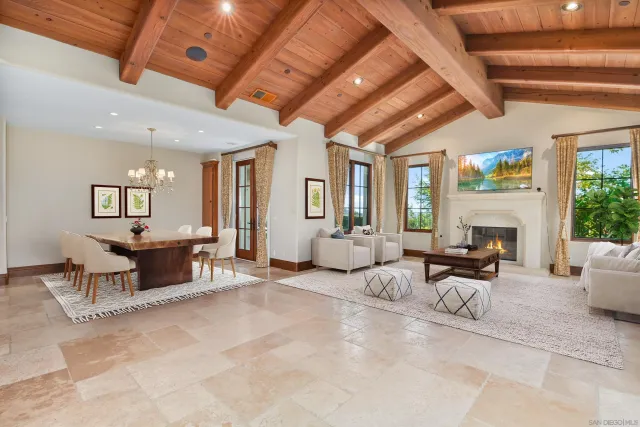 a dining room with wooden floor a chandelier a wooden table and chairs