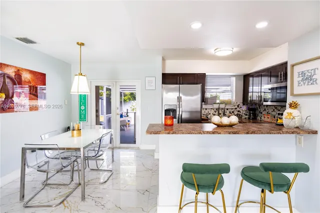 a kitchen with stainless steel appliances kitchen island granite countertop a refrigerator stove microwave and sink