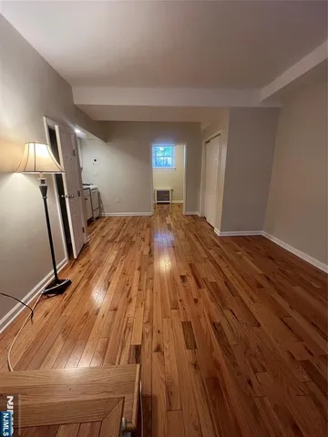 a view of empty room with wooden floor