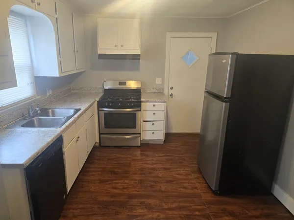 a large kitchen with a refrigerator and a sink