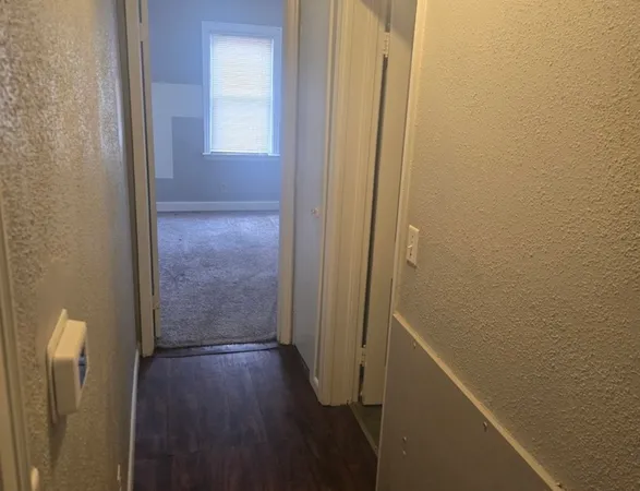 a view of a hallway with wooden floor
