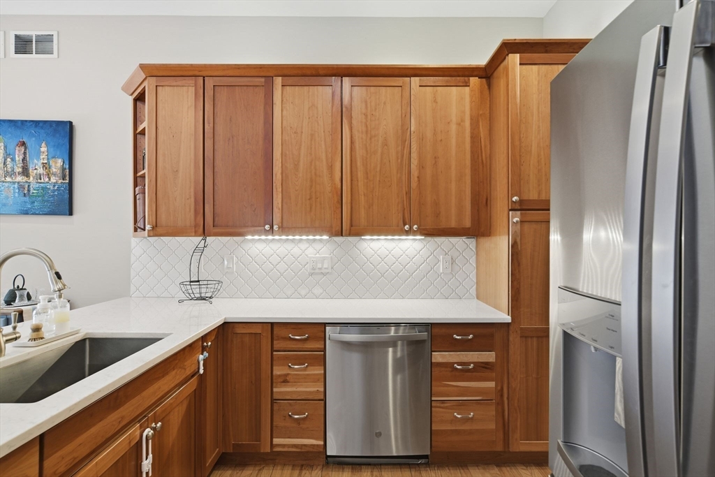 6 Shattuck Road Hadley, MA 01035 - Photo 17 of 40 a kitchen with stainless steel appliances granite countertop a sink and a refrigerator with wooden cabinets