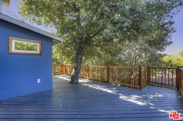 a view of outdoor space with wooden floor and large trees