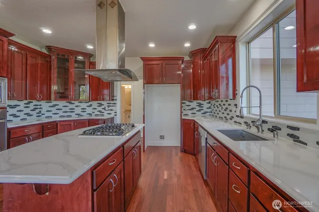 a kitchen with stainless steel appliances granite countertop a sink stove and refrigerator