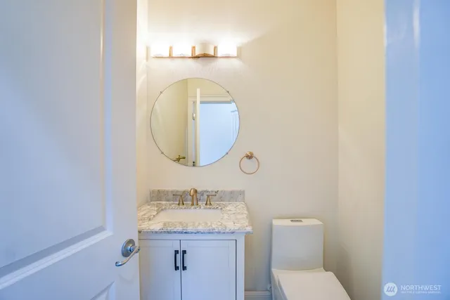 a bathroom with a granite countertop sink mirror and toilet