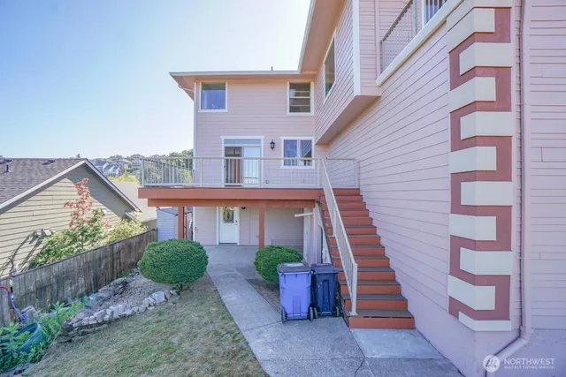 a view of a house with wooden stairs and a small yard