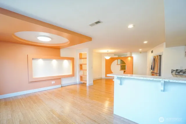a living room with furniture kitchen view and a chandelier