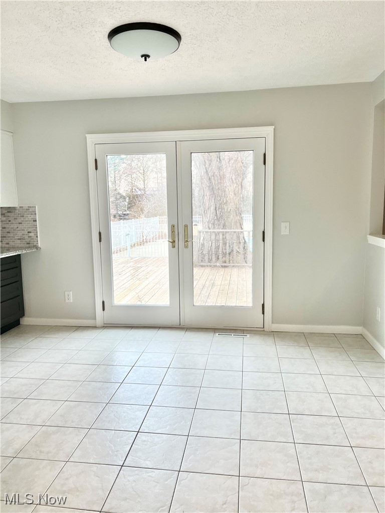 15317 Strader Road East Liverpool, OH 43920 - Photo 6 of 23 Entryway with french doors, light tile patterned floors, and a textured ceiling