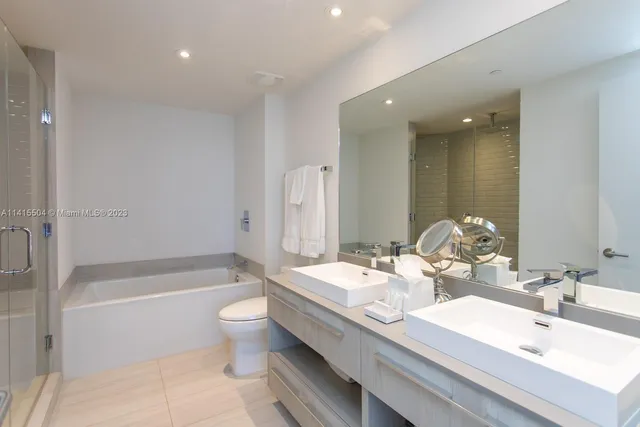 a bathroom with a double vanity sink toilet and shower