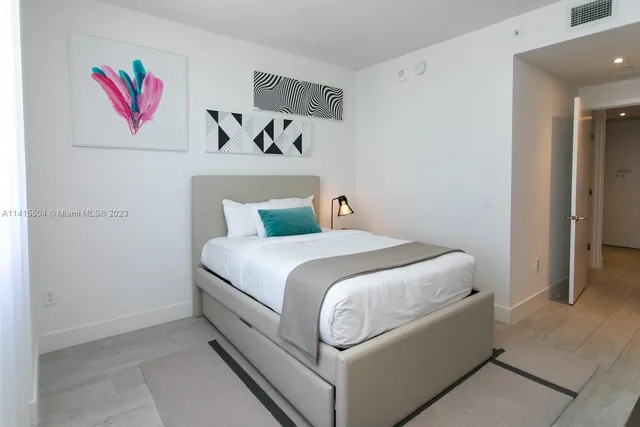 a bedroom with a bed and painting on the wall