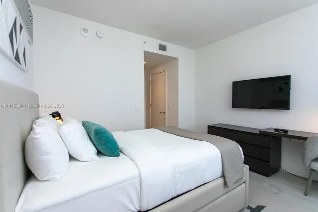 a bedroom with a bed and a flat screen tv