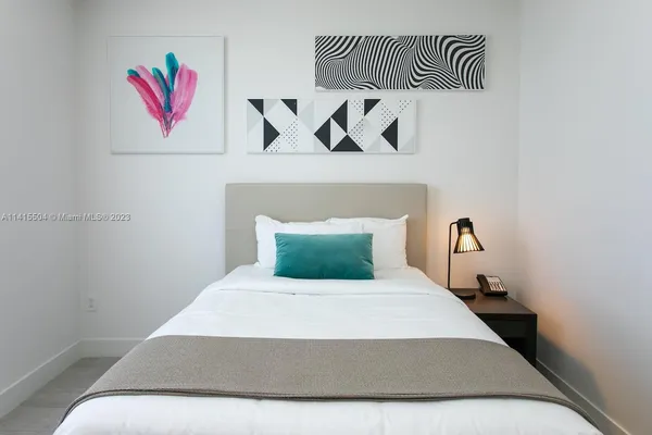 a bedroom with a bed and painting on the wall