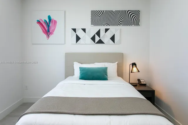 a bedroom with a bed and painting on the wall