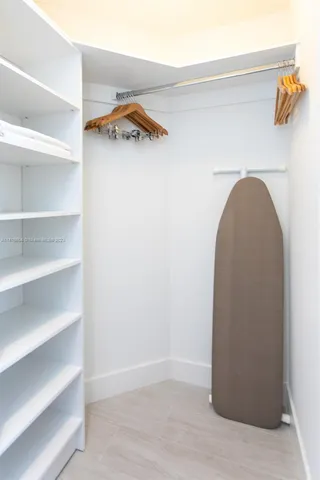 a view of walk in closet with empty racks