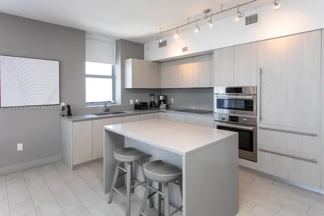 a kitchen with a sink a stove a refrigerator and a cabinets