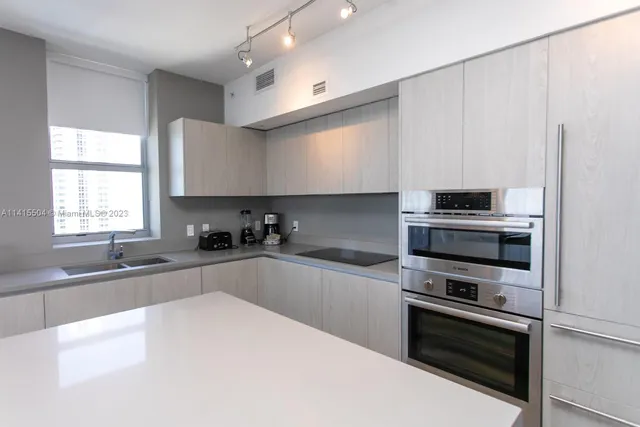a kitchen with granite countertop a sink and stainless steel appliances