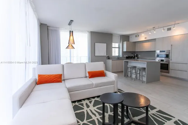 a living room with stainless steel appliances kitchen island granite countertop furniture and a kitchen view