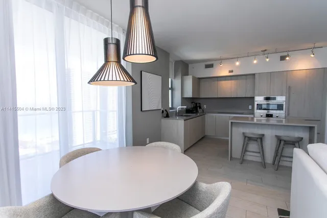 a kitchen with kitchen island a white cabinets and chairs