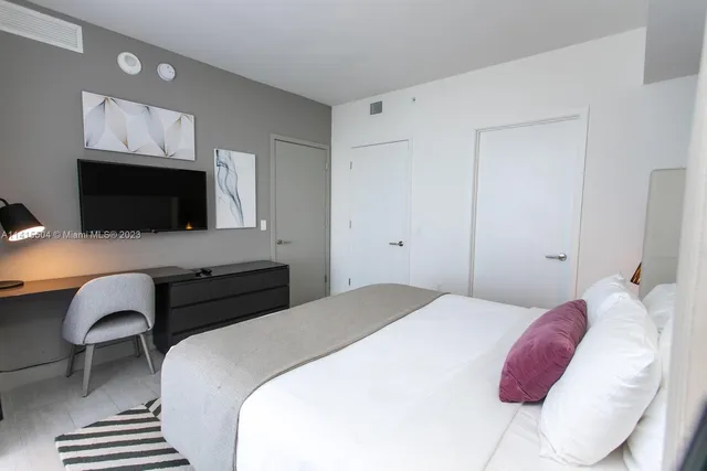 a bedroom with a bed and a flat screen tv
