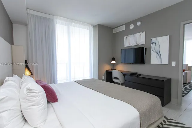 a bedroom with a bed and a television