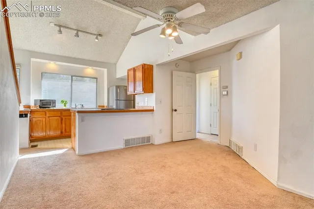 a view of an empty room with a fireplace and a window