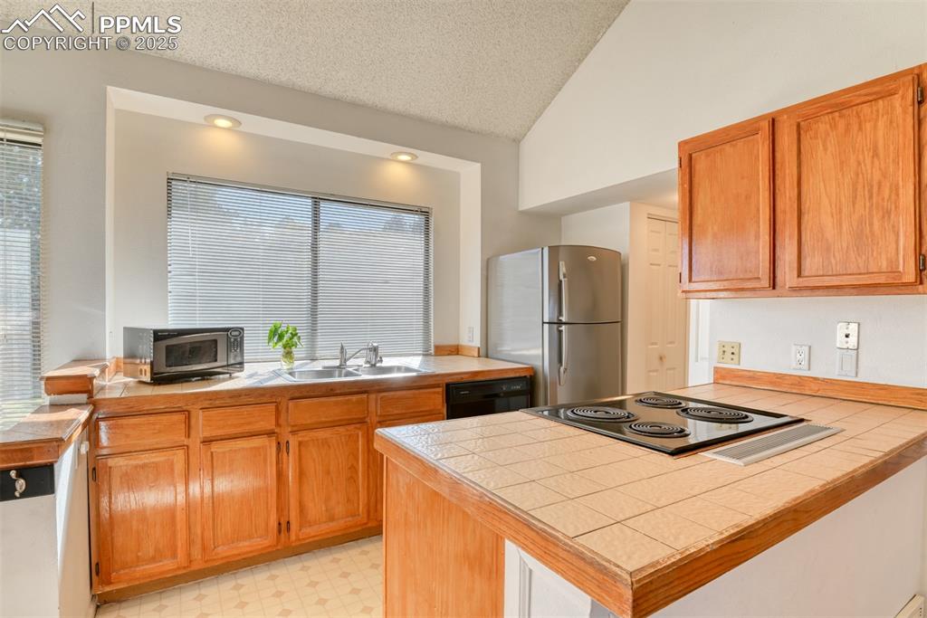 St, Unit A Colorado Springs, CO 80906 - Photo 5 of 37 a kitchen with kitchen island granite countertop a sink stove and refrigerator