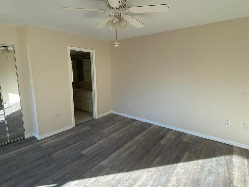 2911 Pecan Avenue Leesburg, FL 34748 - Photo 11 of 26 an empty room with wooden floor fan and windows