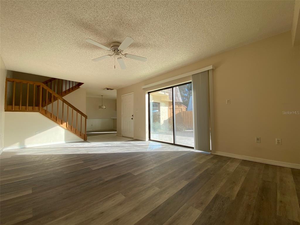 2911 Pecan Avenue Leesburg, FL 34748 - Photo 4 of 26 a view of an empty room with wooden floor and a ceiling fan