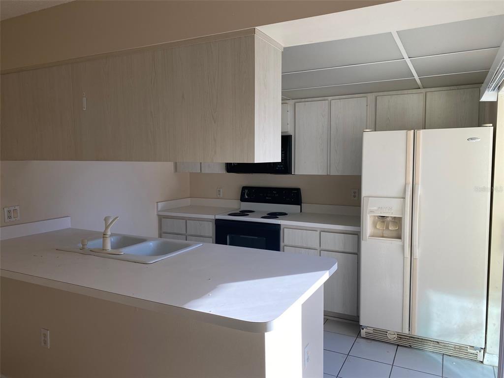 2911 Pecan Avenue Leesburg, FL 34748 - Photo 7 of 26 a kitchen with a refrigerator and a stove